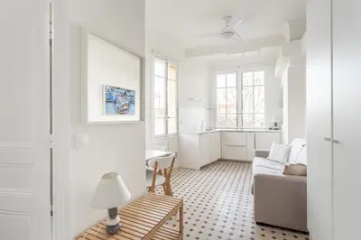 a white living room with a couch and a table at Seaside Studio by iCasamia it in Nice