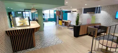 a lobby of a store with a counter and chairs at B&B HOTEL Nice Aéroport Arenas in Nice