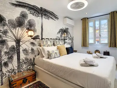 a bedroom with a bed with a palm tree wallpaper at Nestor&Jeeves - LOU FRANCESCAN - Old Town - Close sea - Place St Francois in Nice