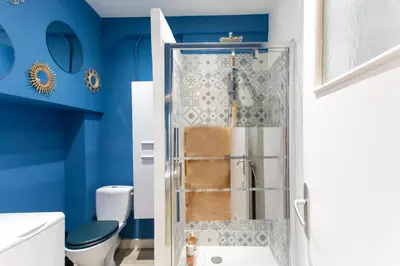 a bathroom with a shower with blue walls at 26 nice , La Riviera in Nice