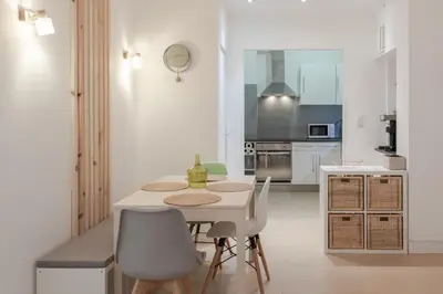 a white kitchen with a table and chairs at 26 nice , La Riviera in Nice