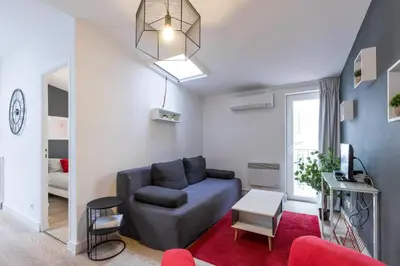 a living room with a blue couch and a red rug at Magenta Square Central 1 Bdr with AC in Nice