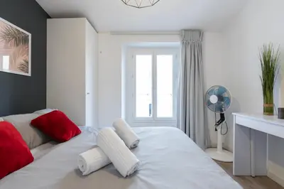 a bedroom with a bed with red and white pillows at Magenta Square Central 1 Bdr with AC in Nice