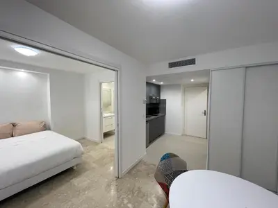 a white bedroom with a bed and a mirror at Petit 2 pièces Carré d'Or in Nice