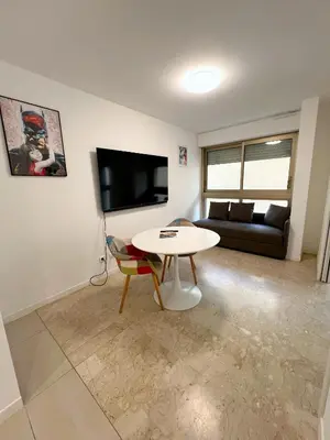 a living room with a table and a couch at Petit 2 pièces Carré d'Or in Nice
