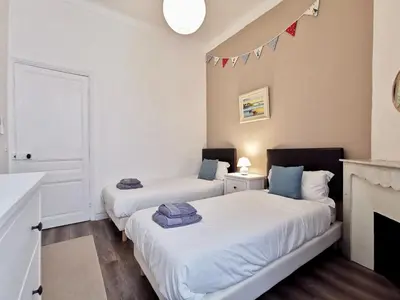 two beds in a room with a fireplace at Congrès Carré d'Or by Booking Guys in Nice