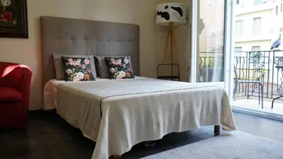 a bedroom with a bed with a white blanket and a window at Cozy studio with a sea view in Nice