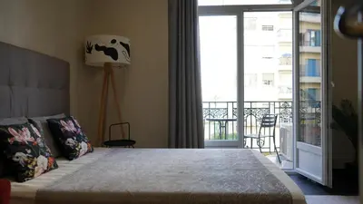 a bedroom with a bed with a view of a balcony at Cozy studio with a sea view in Nice
