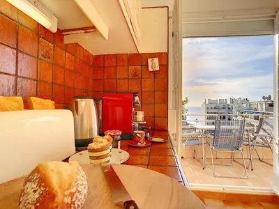 a room with a kitchen with a view of a balcony at Nestor&Jeeves - BEACH COTTAGE TERRACE - Central - Very close sea - Top floor in Nice