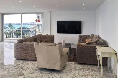 a living room with two couches and a flat screen tv at Promenade des anglais Amazing sea view 140M2 3BR in Nice