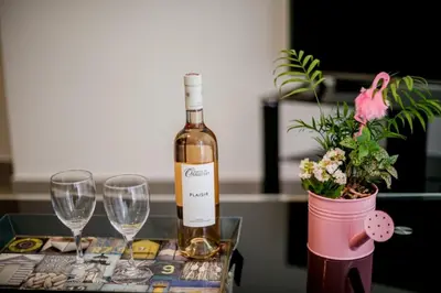 a bottle of wine and two glasses on a table at SUEDE AP4207 by Riviera Holiday Homes in Nice