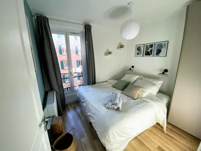 a bedroom with a white bed and a window at Sunny and calm 2 bed apartment place du Pin in Nice