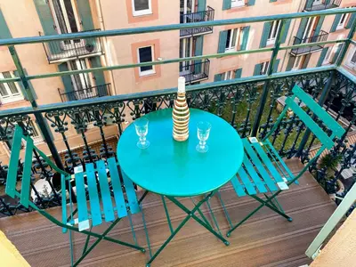 a table with two chairs and a vase on a balcony at Sunny and calm 2 bed apartment place du Pin in Nice