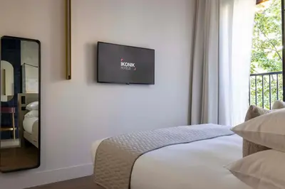 a bedroom with a bed and a chair and a tv at Ikonik Jean Médecin in Nice