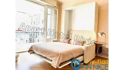 a bedroom with a bed and a large window at ApartHotel Riviera - Hyper Centre Ville - Studio Supérieur AC avec balcon et aperçu mer - BALCON MASSENET 1 in Nice