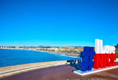 a view of the beach and the sign for long beach at ApartHotel Riviera - Hyper Centre Ville - Studio Supérieur AC avec balcon et aperçu mer - BALCON MASSENET 1 in Nice