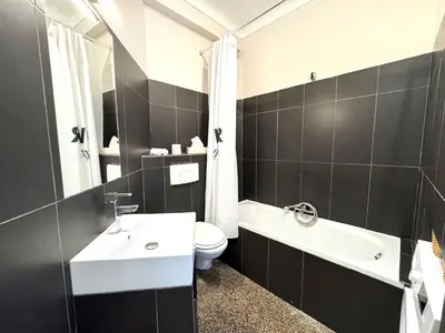 a black and white bathroom with a sink and a toilet at ApartHotel Riviera - Hyper Centre Musiciens - Superior 1 Bedroom Apartement AC - Balcony - 10 mn Promenade des Anglais - BALCON PALAIS EXCELSIOR 1 in Nice