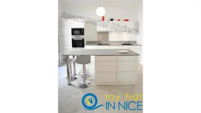 a kitchen with white cabinets and a counter top at ApartHotel Riviera - 2 minutes de la plage - Exceptionnel 2 chambres AC - BALCON MEYERBEER 1 in Nice