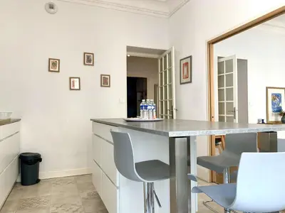 a kitchen with a counter and chairs in a room at ApartHotel Riviera - 2 minutes de la plage - Exceptionnel 2 chambres AC - BALCON MEYERBEER 1 in Nice