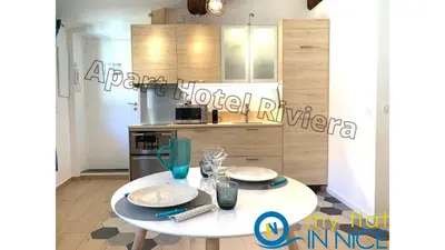 a kitchen with a white table with two plates on it at ApartHotel Riviera - ISTRIA 1- Old town Promenade des Anglais - Superbe Appartement Superior 2 Pièces AC in Nice