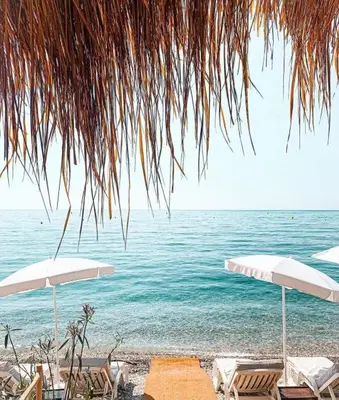 two umbrellas and chairs on a beach with the ocean at Nice Vue Mer 50m plage Parking in Nice
