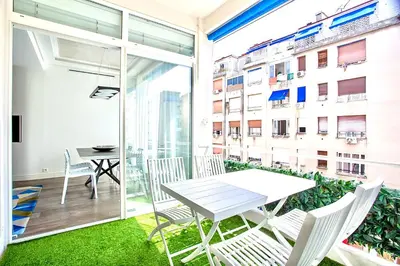 a balcony with a table and chairs and a building at Luxurious 2 Bedrooms Apartment, 30 meter from beach in Nice