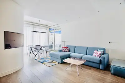 a living room with a blue couch and a table at Luxurious 2 Bedrooms Apartment, 30 meter from beach in Nice