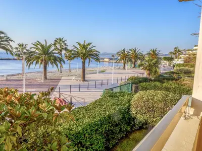 a view of a beach with palm trees and the ocean at Apartment Les Voiliers by Interhome in Saint-Laurent-du-Var