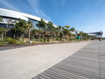 a boardwalk in front of a building with palm trees at Apartment Les Voiliers by Interhome in Saint-Laurent-du-Var