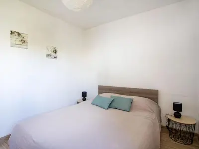a beach with palm trees and the ocean in the background at Apartment Les Voiliers by Interhome in Saint-Laurent-du-Var