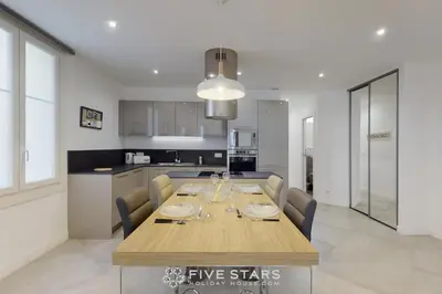 a dining room with a table and a kitchen at Grand Suite Promenade Five stars holiday house in Nice
