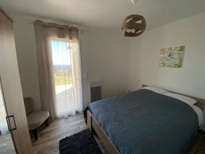 a bedroom with a bed and a large window at Villa Flora in La Gaude