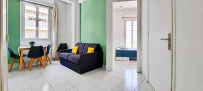 a living room with a blue couch and a table at Appartement 3 pièces Nice Hypercentre in Nice