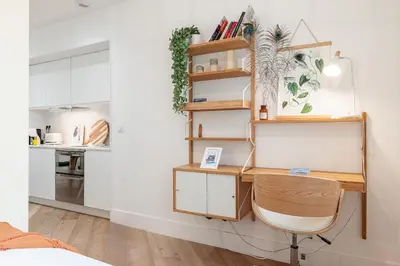 a desk and a chair in a room with a kitchen at 60 HEROLD - Magnifique Studio - Terrasse - Climatise in Nice