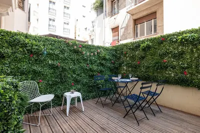 a patio with chairs and tables in front of a hedge at 60 HEROLD - Magnifique Studio - Terrasse - Climatise in Nice