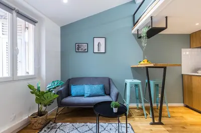 a living room with a blue chair and a table at 1 GALLO LOT 2 - Studio Mezzanine en plein coeur du vieux Nice in Nice