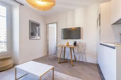 a living room with a table and a tv at 2 BAVASTRO - Beau 2 pieces lumineux et cosy - Climatise in Nice
