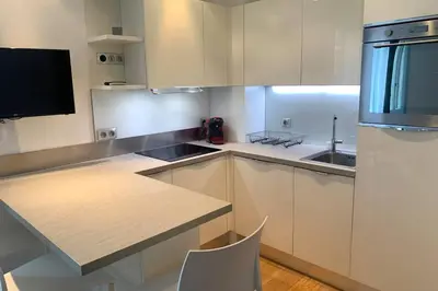 a kitchen with white cabinets and a sink and a counter at Le Lafayette HP in Nice