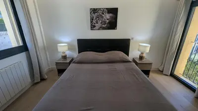 a bedroom with a large bed with two lamps at Les Volets Bleus in Nice