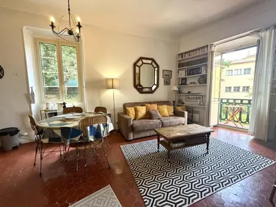 a living room with a table and a couch at ApartHotel Riviera - BALCON HONORE 1 - Old Town - 5 mn Promenade des Anglais et Plage - Charme Absolu - Appartement 2 pièces avec Balcon AC - Vue mer et Ville in Nice
