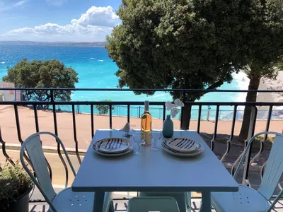 a blue table with a view of the beach at I love Nice - FACE MER, DESIGN, TERRASSE, ASC, WIFI, CLIM in Nice