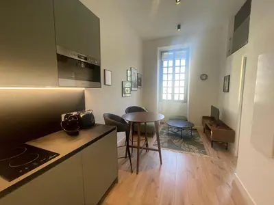 a kitchen with a table and a dining room at Garibaldi 11 in Nice