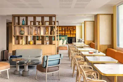 a row of tables and chairs in a restaurant at OKKO Hotels Nice Aéroport in Nice