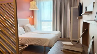 a hotel room with two beds and a window at OKKO Hotels Nice Aéroport in Nice