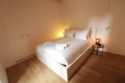 a bedroom with a white bed with a light on it at Superbe Appartement au coeur de la vieille ville in Villefranche-sur-Mer