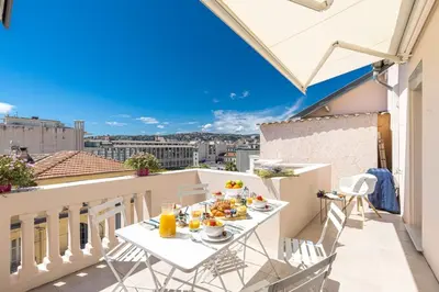 a breakfast table on a balcony with a view of the city at MY CASA - SPITALIERI- Sunny Terrace with view in Nice