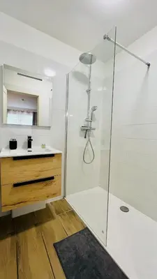 a white bathroom with a shower and a sink at LE MIRAMAR Nice - Clim, Parking, Wifi et piscine in Nice