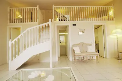 a living room with a staircase and a chair at AMAZING SEA VIEW APARTMENT with Private Close Parking in Saint-Jean-Cap-Ferrat