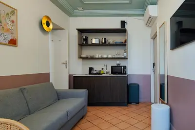 a living room with a couch and a kitchen at Hotel Aparthotel AMMI Vieux Nice in Nice