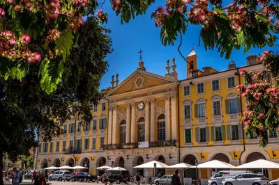 a large yellow building with a clock on it at Hotel Aparthotel AMMI Vieux Nice in Nice
